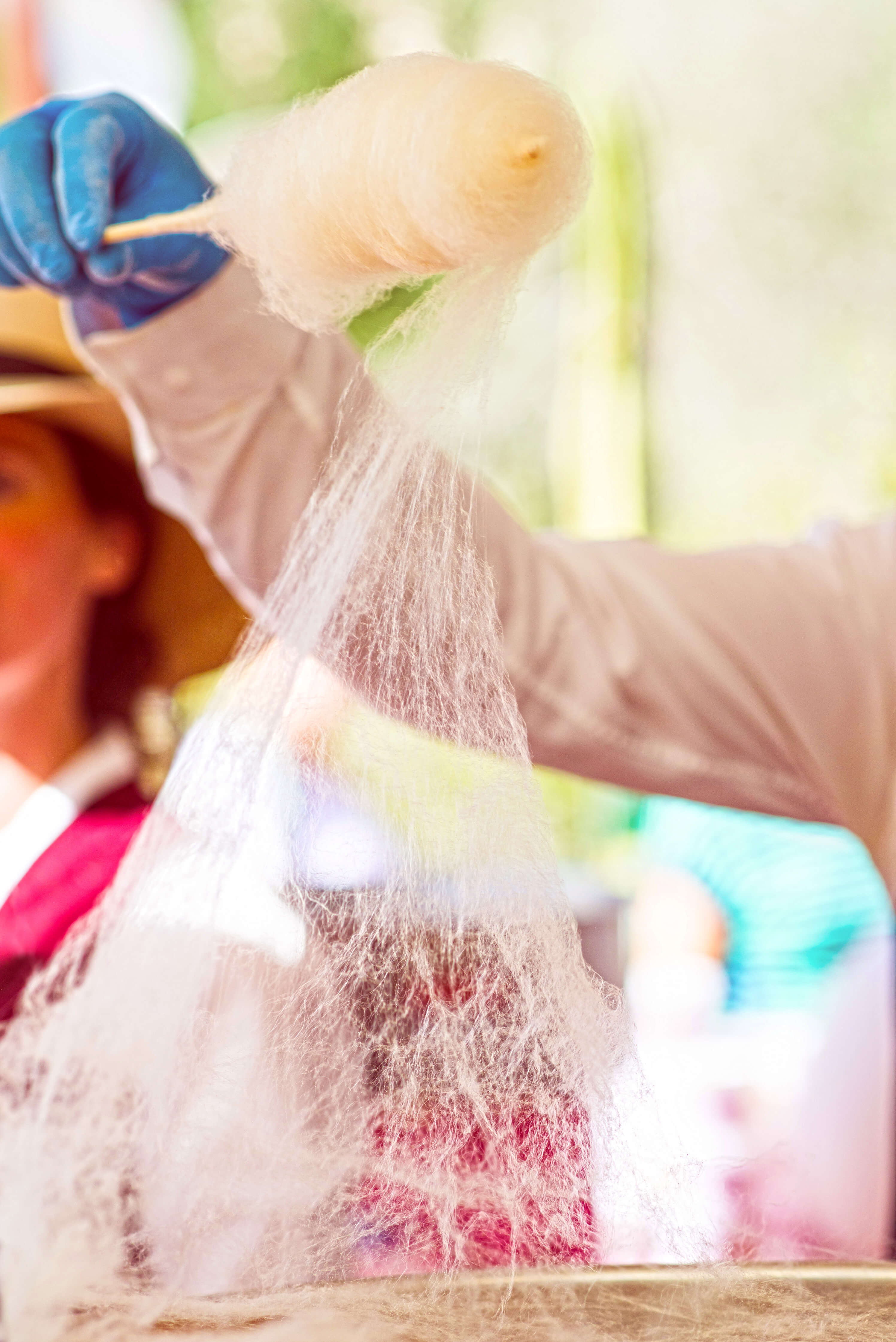 A person pulling cotton candy at the Chiles and Chocolate event at the Desert Botanical Gardens