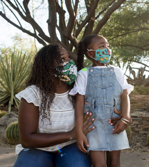 Mother and daughter in masks at desert botanical garden