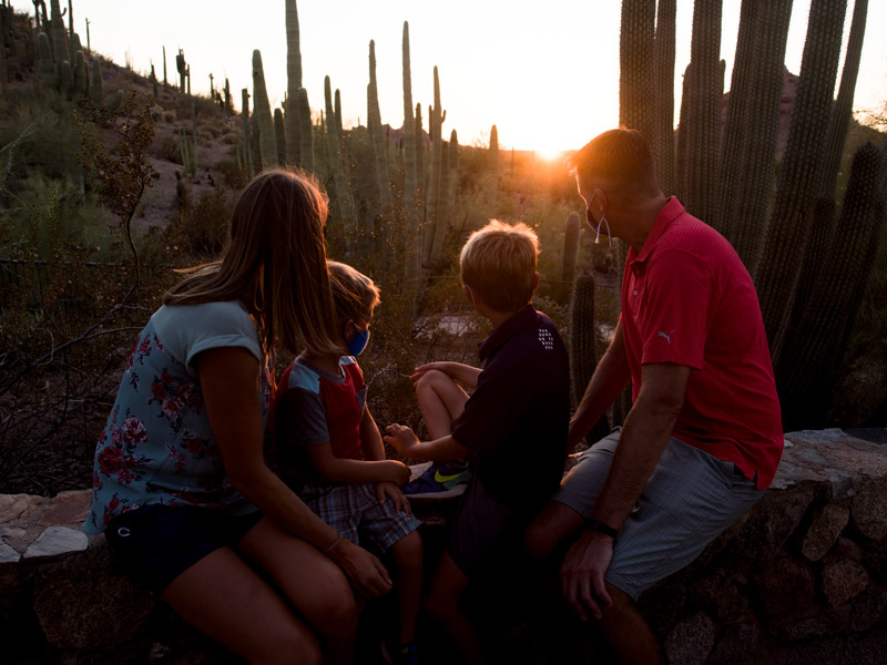 Familia mirando la puesta de sol en el jardín botánico del desierto